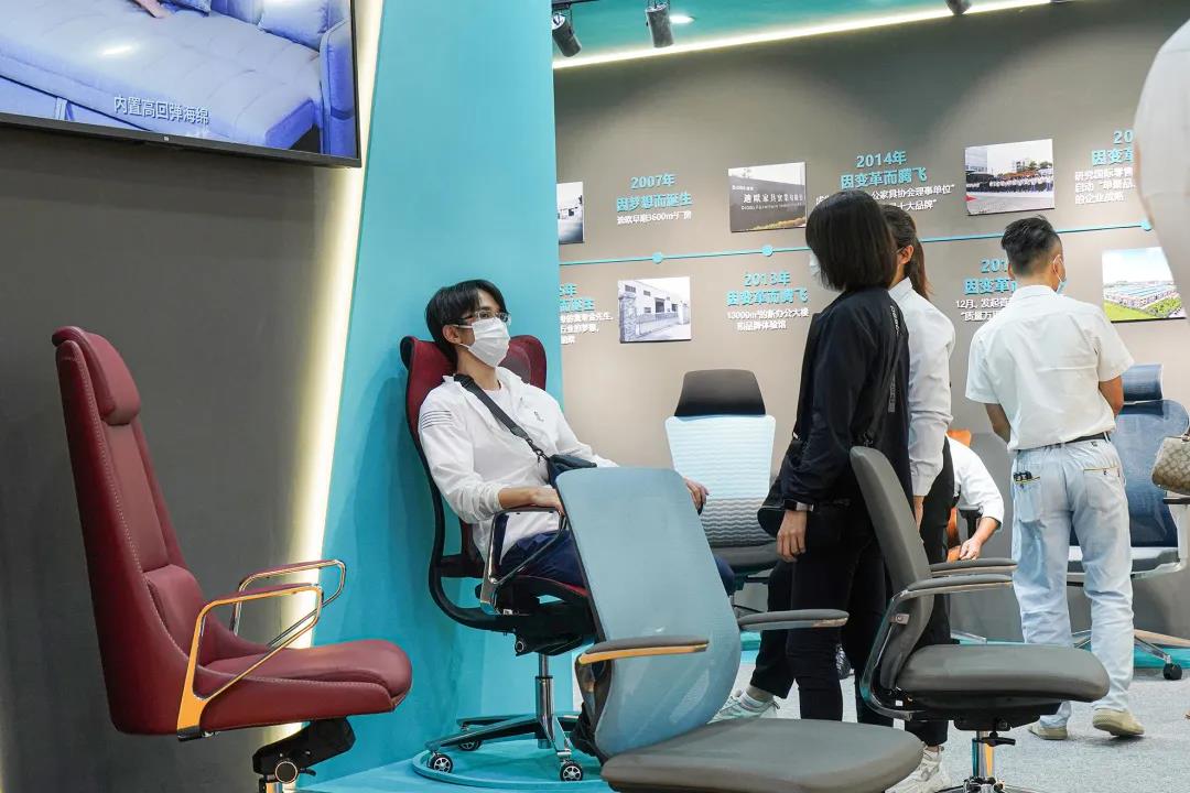 图丨客商们在羞羞视频免费在线观看展位现场体验办公坐具的产品性能